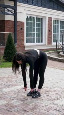 Genç bir kız dışarıda bir dinlenme tesisinde fiziksel egzersiz yapıyor..