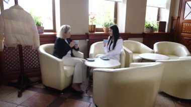 Masadaki kafede konuşan ve kahve içen iki kadın..