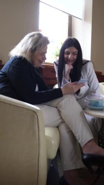 Masadaki kafede konuşan ve kahve içen iki kadın..