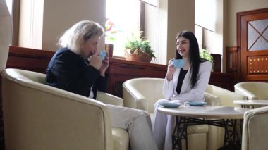 Masadaki kafede konuşan ve kahve içen iki kadın..