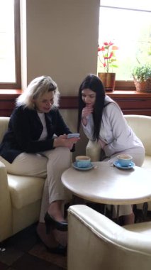 Masadaki kafede konuşan ve kahve içen iki kadın..