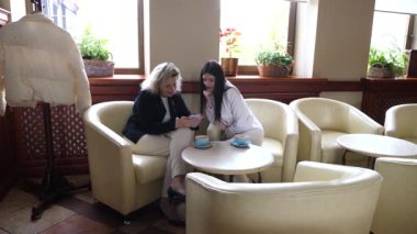 Masadaki kafede konuşan ve kahve içen iki kadın..