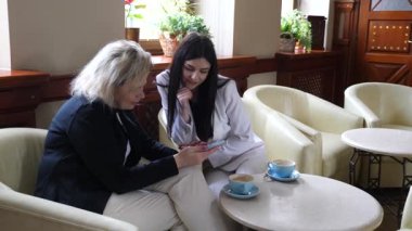 Masadaki kafede konuşan ve kahve içen iki kadın..