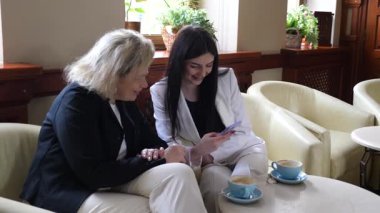 Masadaki kafede konuşan ve kahve içen iki kadın..