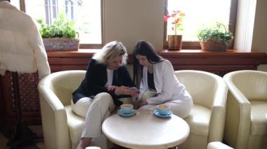 Masadaki kafede konuşan ve kahve içen iki kadın..