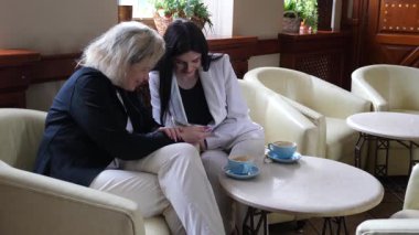 Masadaki kafede konuşan ve kahve içen iki kadın..