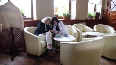 Masadaki kafede konuşan ve kahve içen iki kadın..