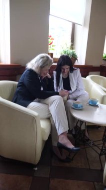 Masadaki kafede konuşan ve kahve içen iki kadın..