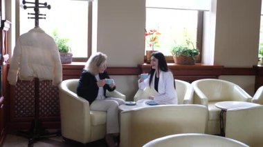 Masadaki kafede konuşan ve kahve içen iki kadın..