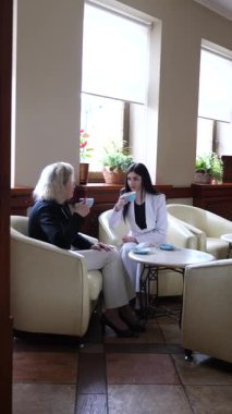 Masadaki kafede konuşan ve kahve içen iki kadın..