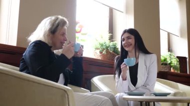 Masadaki kafede konuşan ve kahve içen iki kadın..