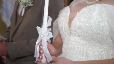 Gelin ve damat bir kilise düğününde mum tutarlar..