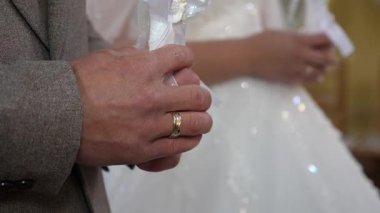 Gelin ve damat bir kilise düğününde mum tutarlar..