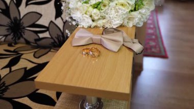 İki altın alyans, bir buket düğün ve papyon..