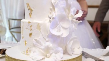 Gelin ve damat tarafından kesilen güzel düğün pastası. Düğün gelenekleri..