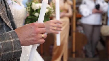 Gelin ve damat bir kilise düğününde mum tutarlar..