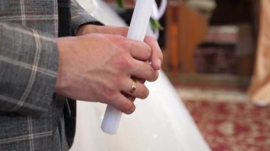 Gelin ve damat bir kilise düğününde mum tutarlar..