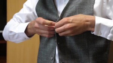 Adam ceketinin düğmelerini ilikliyor. Şık erkek kıyafetleri..