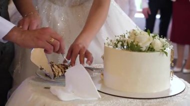 Gelin ve damat tarafından kesilen güzel düğün pastası. Düğün gelenekleri..