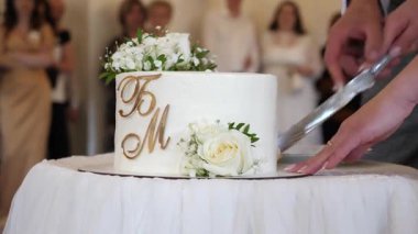 Gelin ve damat tarafından kesilen güzel düğün pastası. Düğün gelenekleri..