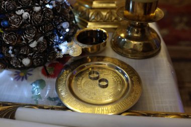 Altın tepside alyanslar ve kilisedeki tahtta bir bardak şarap. Kilise düğünü.