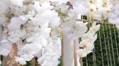 Beyaz çiçeklerle süslenmiş mimari kemer. Şenlik Dekoru.