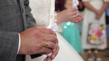 Gelin ve damat bir kilise düğününde mum tutarlar..