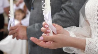 Gelin ve damat bir kilise düğününde mum tutarlar..