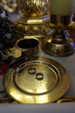 Altın tepside alyanslar ve kilisedeki tahtta bir bardak şarap. Kilise düğünü.