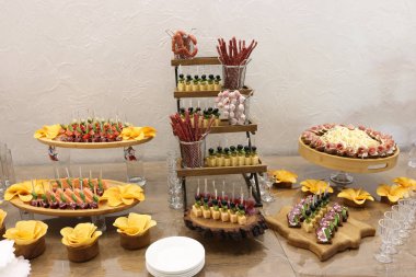 Tütsülenmiş et, peynir ve patates kızartmasıyla dolu tuzlu büfe masası.