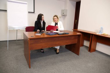 İki kadın iş konularını tartışıyor, bilgiyi analiz ediyor.