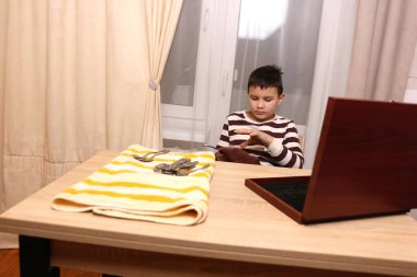 Oğlan çatal ve mutfak bıçaklarını siliyor. Ev işleri..