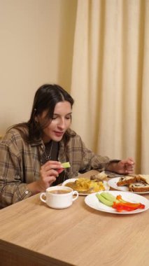 Güzel bir kız masada oturuyor, yiyor ve içiyor..