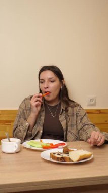 Güzel bir kız masada oturuyor, yiyor ve içiyor..