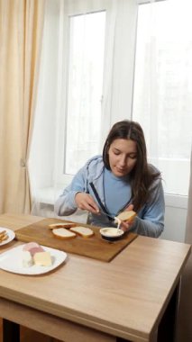 Peynirli ve sosisli sandviç hazırlayan kız. Ev yemeği..