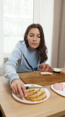 Peynirli ve sosisli sandviç hazırlayan kız. Ev yemeği..