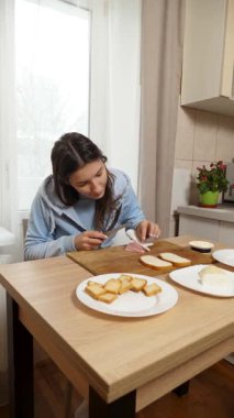 Peynirli ve sosisli sandviç hazırlayan kız. Ev yemeği..