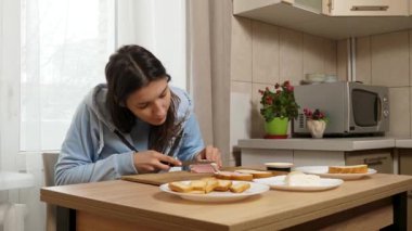 Peynirli ve sosisli sandviç hazırlayan kız. Ev yemeği..