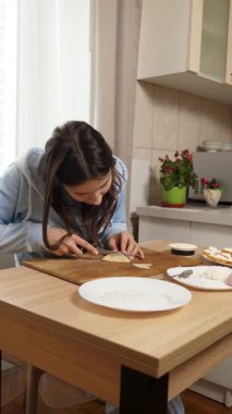 Peynirli ve sosisli sandviç hazırlayan kız. Ev yemeği..