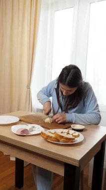 Peynirli ve sosisli sandviç hazırlayan kız. Ev yemeği..