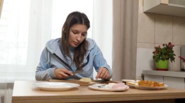 Peynirli ve sosisli sandviç hazırlayan kız. Ev yemeği..