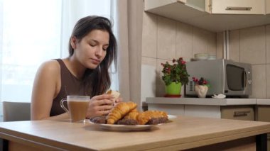 Çörek yiyen ve kahve içen bir kız. Nefis kahvaltı..