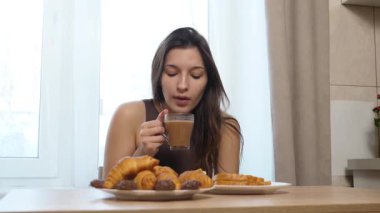 Çörek yiyen ve kahve içen bir kız. Nefis kahvaltı..