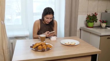 Kız masada oturuyor, kahve içiyor ve şeker yiyor..