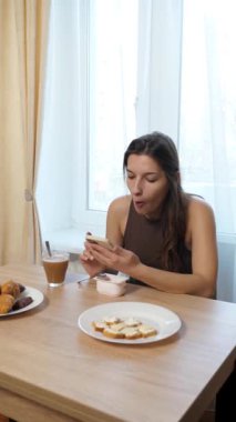 Kız masada oturuyor, kahve içiyor ve şeker yiyor..