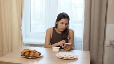 Kız masada oturuyor, kahve içiyor ve şeker yiyor..