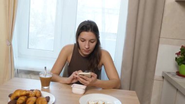 Kız masada oturuyor, kahve içiyor ve şeker yiyor..