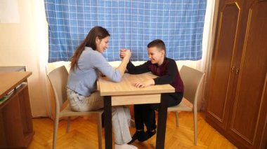 Bir kız küçük erkek kardeşiyle domino oynar. Boş oyunlar.