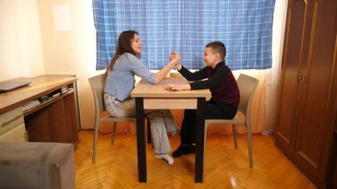 Bir kız ve bir oğlan bilek güreşinde yarışıyorlar. Boş oyunlar.