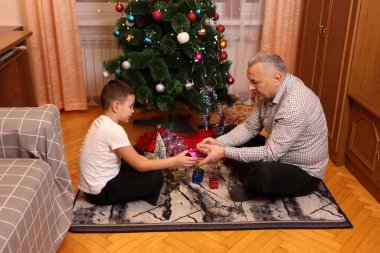 Baba oğul Noel ağacı süslüyorlar. Yılbaşı ve Noel tatili.